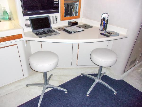 Slide: The Image of Interior of 1992 Sea Ray 400 Express Cruiser with desk, stools, and laptop. - 13