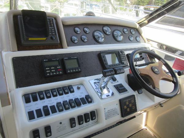 Slide: The Image of 1995 Sea Ray 400 Express Cruiser helm with gauges, controls, and steering wheel. - 21
