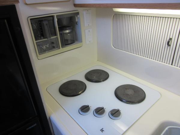 Slide: The Image of 1995 Sea Ray 400 Express Cruiser kitchen with electric stove and built-in appliances. - 29