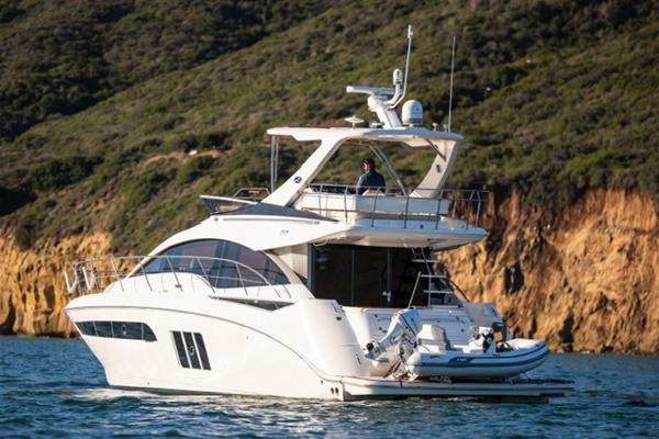 Slide: The Image of 2015 Sea Ray 510 Fly yacht cruising near rocky coastline. - 0