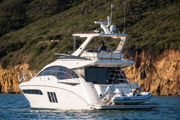 Slide: The Image of 2015 Sea Ray 510 Fly yacht cruising near rocky coastline. - 19