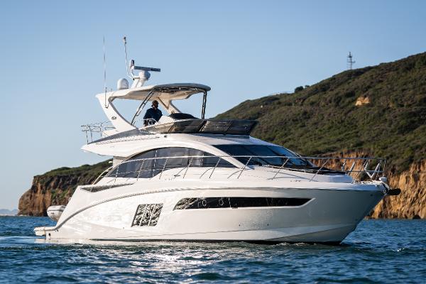 Slide: The Image of 2015 Sea Ray 510 Fly yacht cruising near rocky coastline under clear sky. - 3