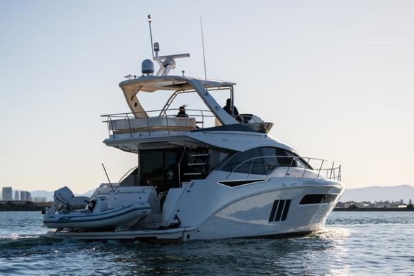 Slide: The Image of 2015 Sea Ray 510 Fly yacht cruising on calm waters at sunset. - 34