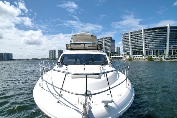 Slide: The Image of Sea Ray 510 Fly 2015 yacht cruising near modern waterfront buildings under blue sky. - 4