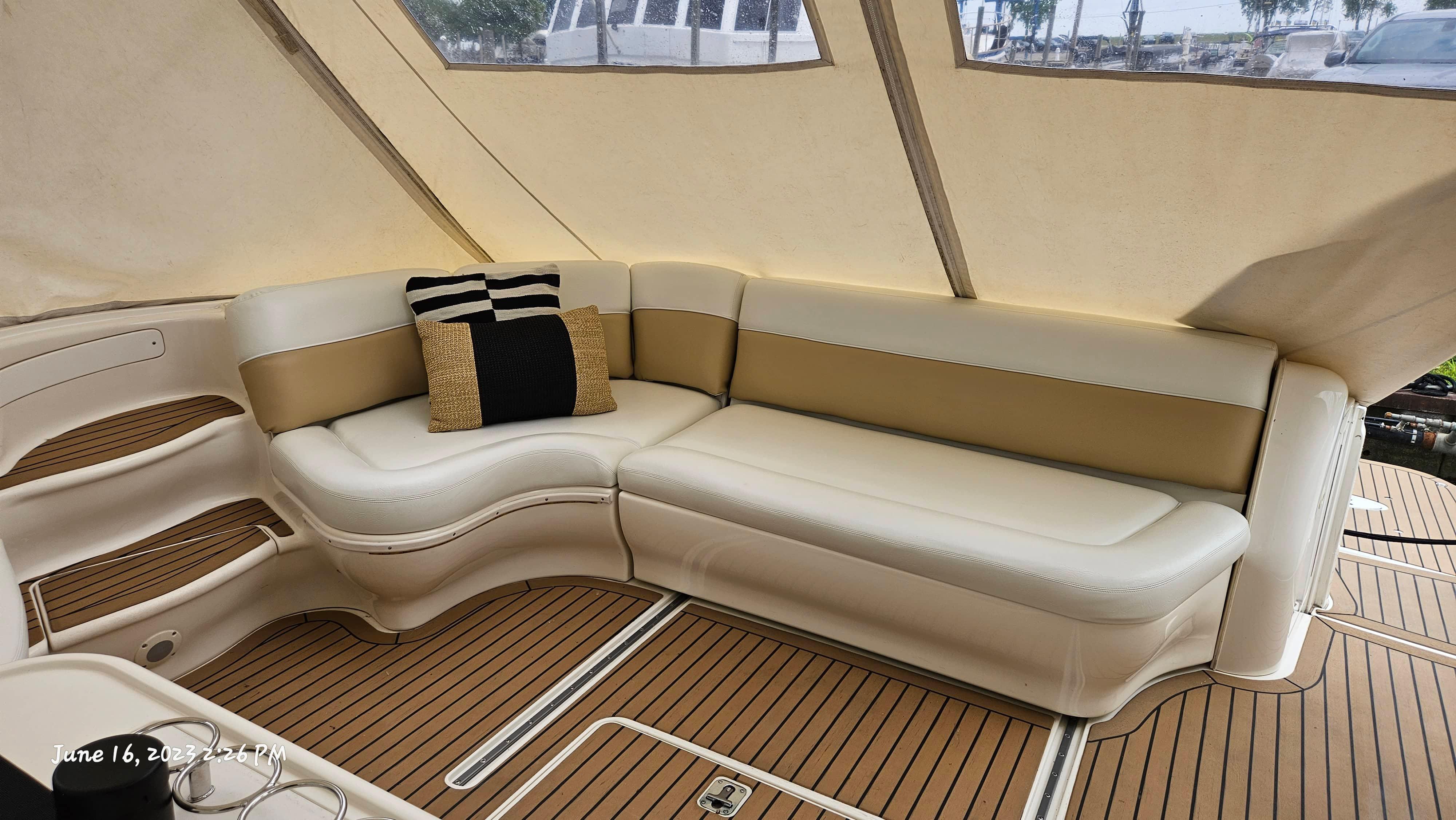Slide: The Image of Interior seating area of a 1999 Sea Ray 540 Sundancer yacht with beige and white cushions. - 1