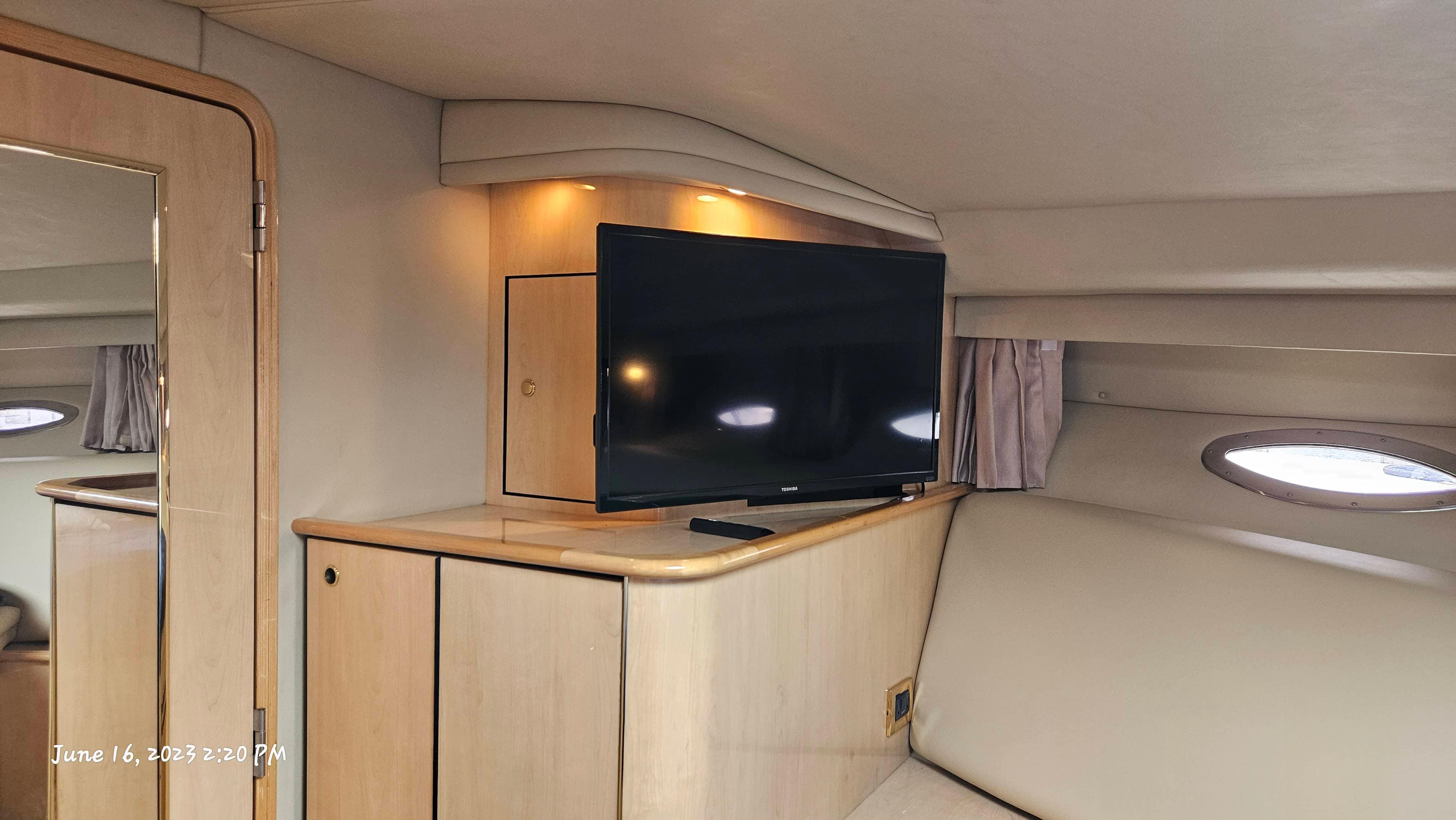 Slide: The Image of Interior of 1999 Sea Ray 540 Sundancer with TV and wooden cabinetry. - 23