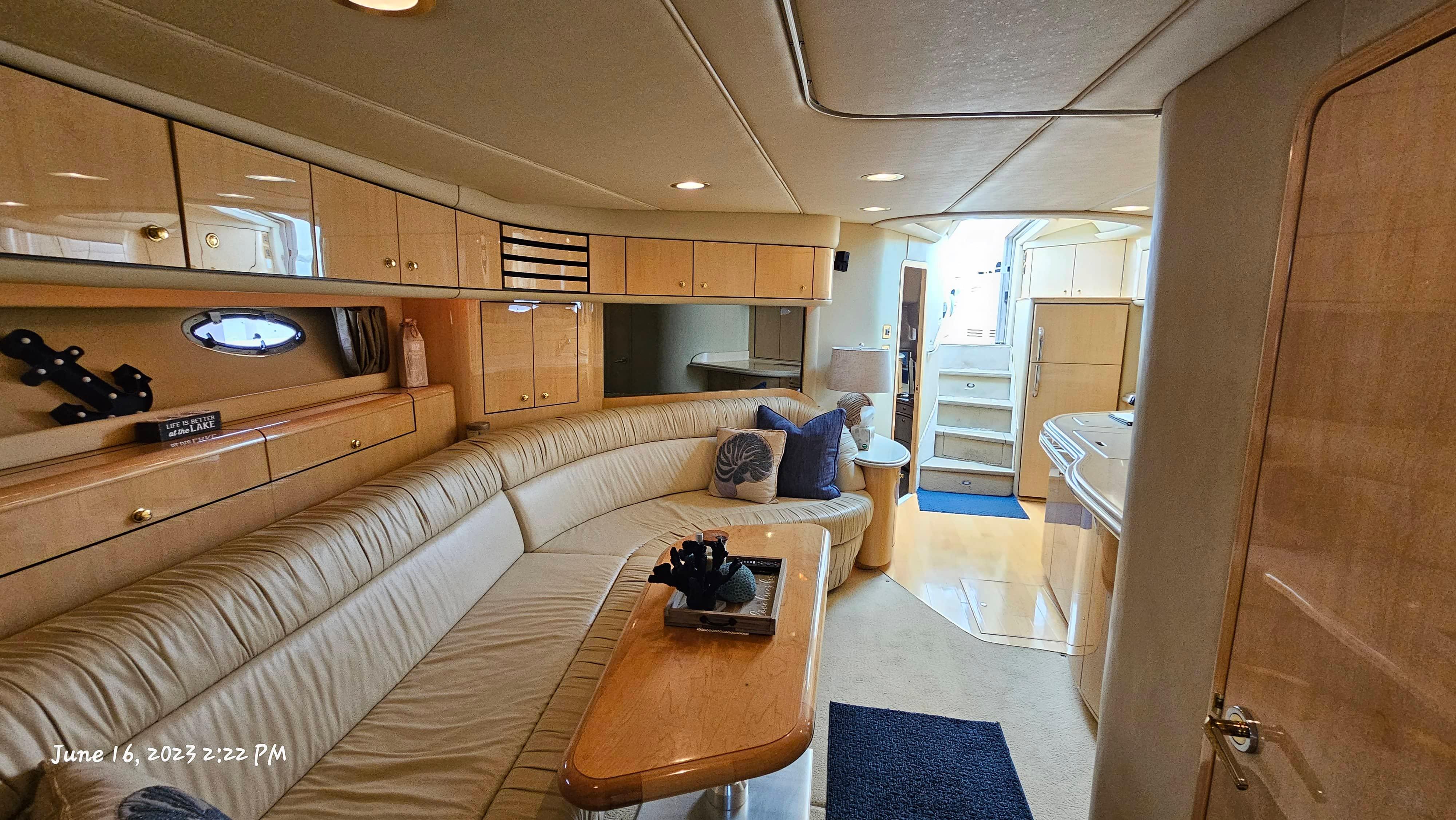 Slide: The Image of Interior of 1999 Sea Ray 540 Sundancer yacht with beige leather seating and wooden cabinetry. - 26