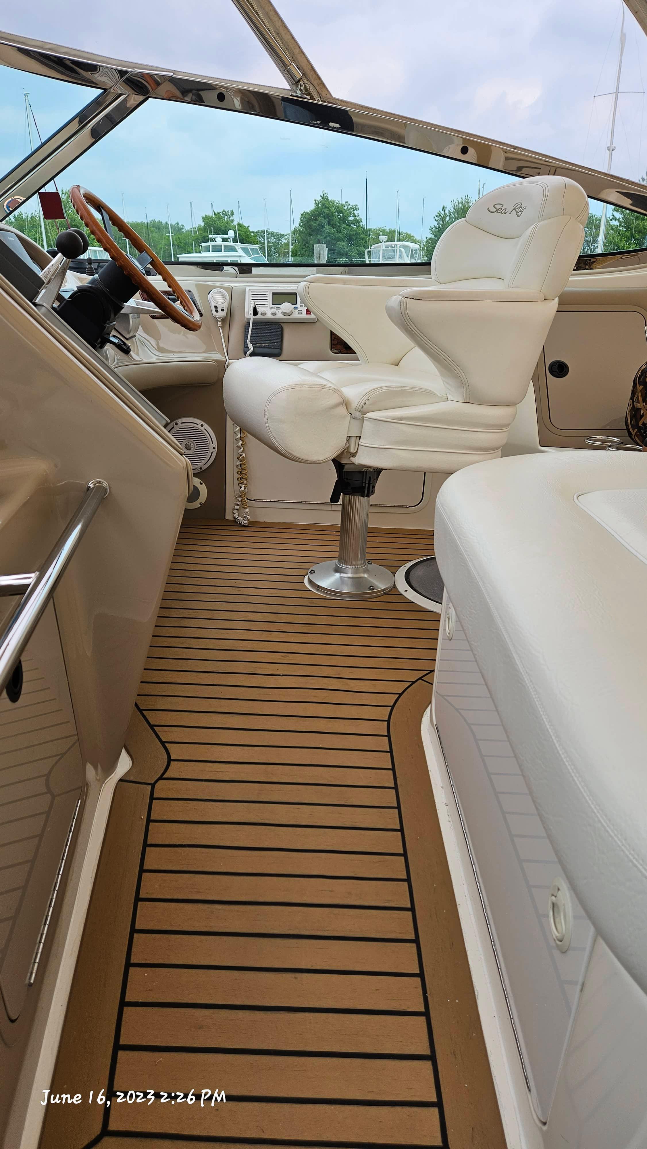 Slide: The Image of Interior of 1999 Sea Ray 540 Sundancer boat with white captain's chair and wooden steering wheel. - 32