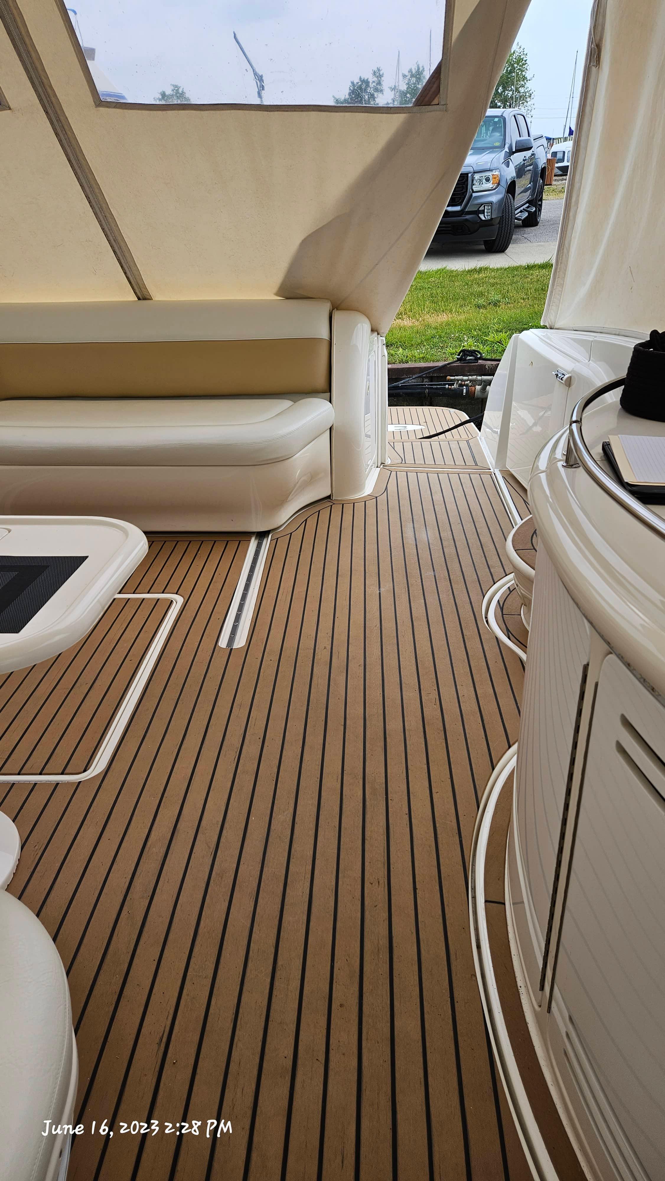 Slide: The Image of Interior of 1999 Sea Ray 540 Sundancer yacht with teak flooring and white seating. - 39