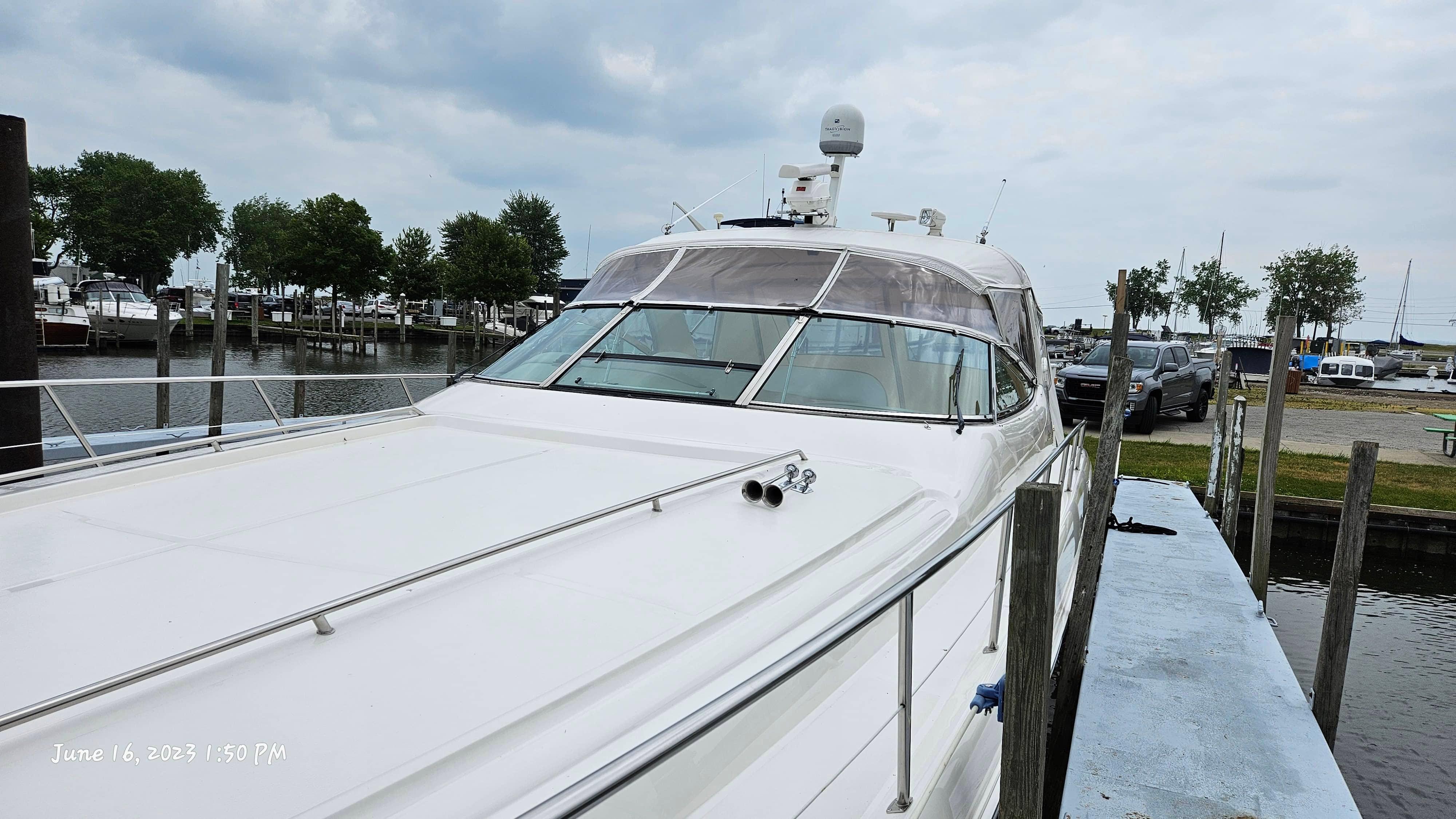 Slide: The Image of 1999 Sea Ray 540 Sundancer docked at a marina on a cloudy day. - 7