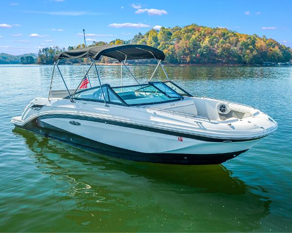 Slide: The Image of 2021 Sea Ray SDX 250 boat on a serene lake with scenic background. - 0