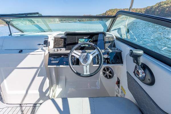Slide: The Image of 2021 Sea Ray SDX 250 boat cockpit with steering wheel and dashboard on a sunny day. - 19