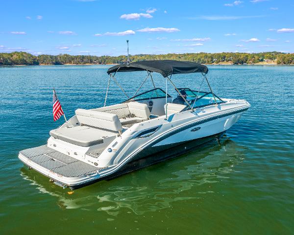 Slide: The Image of 2021 Sea Ray SDX 250 boat on a serene lake with an American flag. - 2