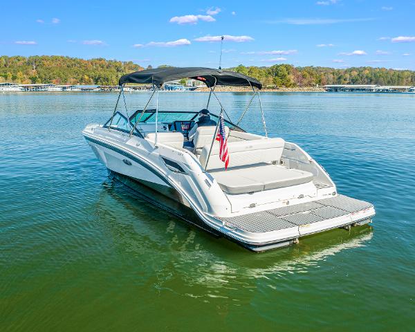Slide: The Image of 2021 Sea Ray SDX 250 boat on a calm lake with a canopy and American flag. - 7
