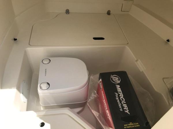 Slide: The Image of Portable toilet and Mercury propeller box in 2025 Sea Ray SDX 250 boat compartment. - 18