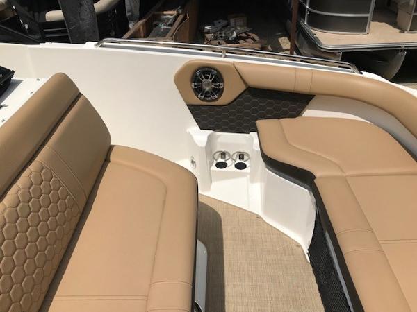 Slide: The Image of 2025 Sea Ray SDX 250 boat interior with tan seating and cup holders. - 21