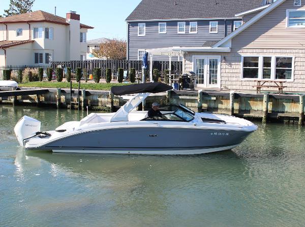 Slide: The Image of 2020 Sea Ray SDX 270 OB boat cruising near waterfront homes. - 16