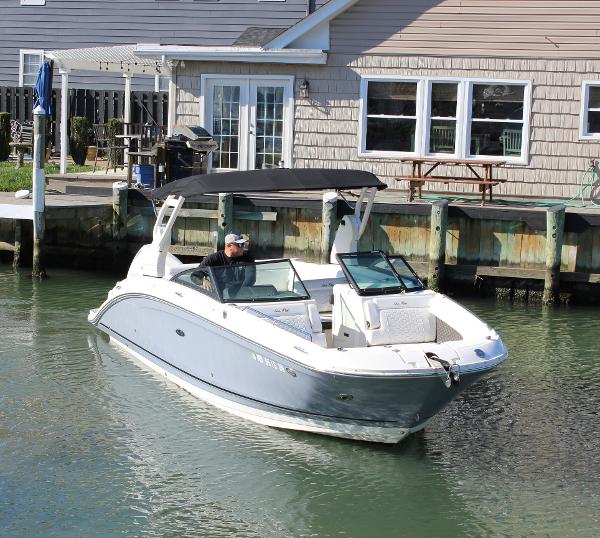 Slide: The Image of 2020 Sea Ray SDX 270 OB boat docked near a waterfront house. - 18