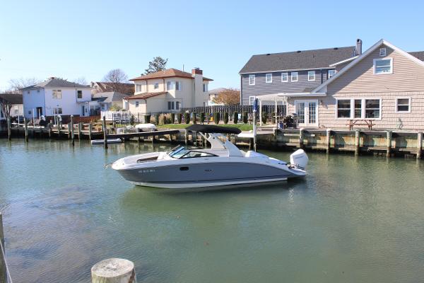 Slide: The Image of 2020 Sea Ray SDX 270 OB boat cruising in a residential canal. - 3