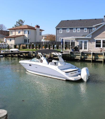 Slide: The Image of 2020 Sea Ray SDX 270 OB boat docked in a residential canal. - 8