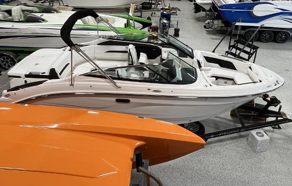 Slide: The Image of 2024 Sea Ray SLX 260 boat in showroom, surrounded by other boats. - 57