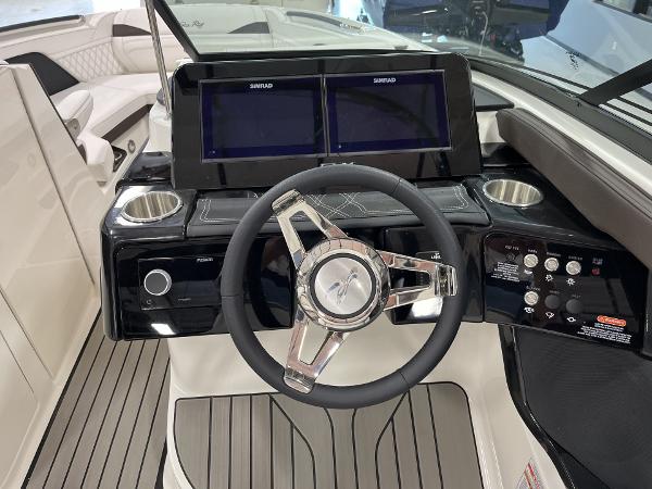 Slide: The Image of 2024 Sea Ray SLX 260 boat dashboard with dual Simrad displays and modern steering wheel. - 70