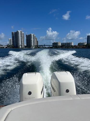 Slide: The Image of 2021 Sea Ray SLX 310 OB cruising on water with city skyline in background. - 7