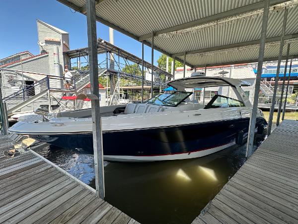Slide: The Image of 2023 Sea Ray SLX 400 OB docked under a covered marina. - 0