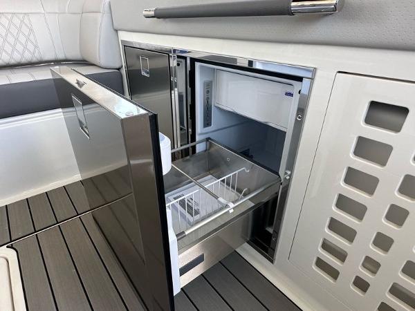 Slide: The Image of 2023 Sea Ray SLX 400 OB boat interior with open refrigerator drawer. - 13