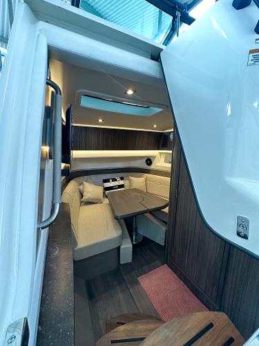 Slide: The Image of 2023 Sea Ray SLX 400 OB cabin interior with seating and table. - 14