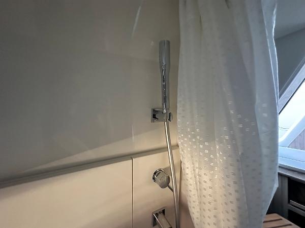 Slide: The Image of Shower area in 2023 Sea Ray SLX 400 OB boat with white curtain. - 22