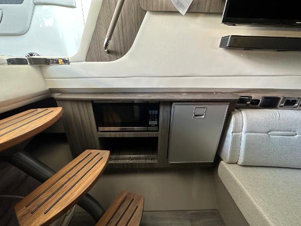 Slide: The Image of Interior of 2023 Sea Ray SLX 400 OB with wooden steps and built-in microwave. - 24