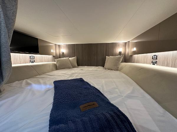 Slide: The Image of Luxurious cabin interior of 2023 Sea Ray SLX 400 OB with cozy bedding and ambient lighting. - 30