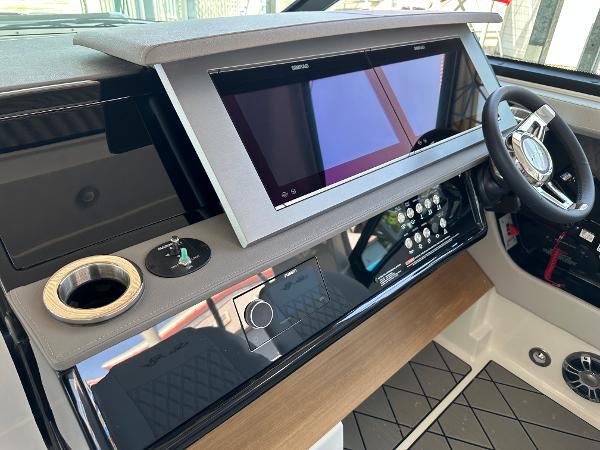 Slide: The Image of 2023 Sea Ray SLX 400 OB helm with modern touchscreen display and steering wheel. - 6