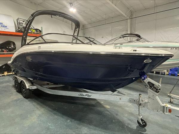 Slide: The Image of 2024 Sea Ray 210 SPX boat on trailer in indoor showroom. - 1