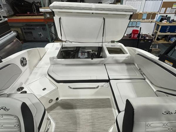 Slide: The Image of 2024 Sea Ray 210 SPX boat interior with open engine compartment in a workshop. - 4