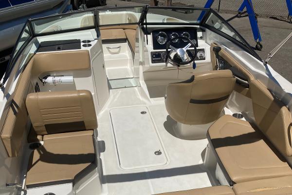 Slide: The Image of 2021 Sea Ray SPX 210 OB boat interior with beige seating and modern dashboard. - 11
