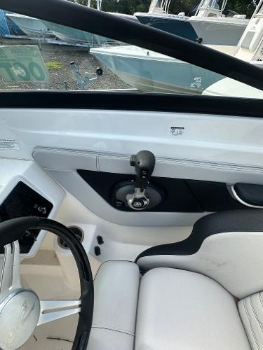 Slide: The Image of 2021 Sea Ray SPX 210 OB boat interior with steering wheel and throttle control. - 12
