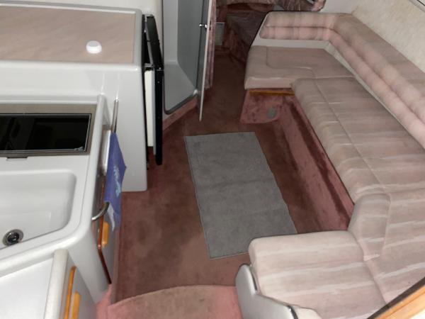 Slide: The Image of 1990 Sea Ray Sundancer interior with kitchenette and seating area. - 2