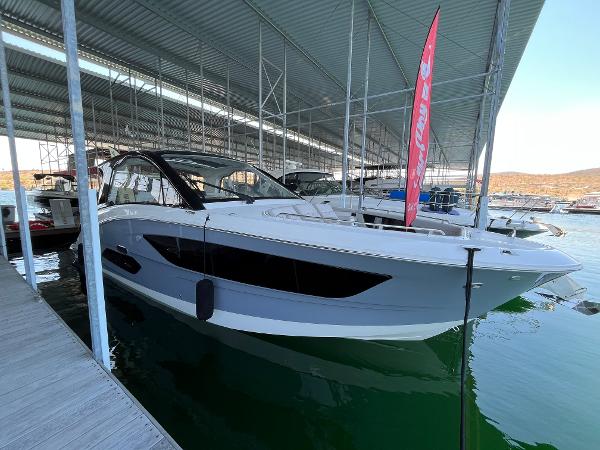Slide: The Image of 2025 Sea Ray Sundancer 370 OB docked in a marina under a covered structure. - 0