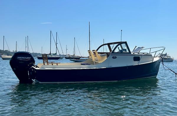 Slide: The Image of 2021 Seaway 21 Seafarer Cuddy boat on water, with Mercury outboard motor. - 0