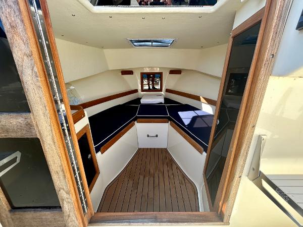 Slide: The Image of Interior of 2021 Seaway 21 Seafarer Cuddy with wood accents and blue cushions. - 10