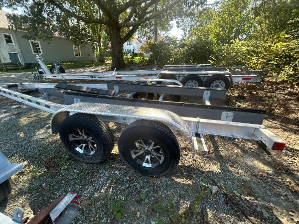 Slide: The Image of 2021 Seaway 21 Seafarer Cuddy trailer parked outdoors, dual axle, surrounded by trees. - 15