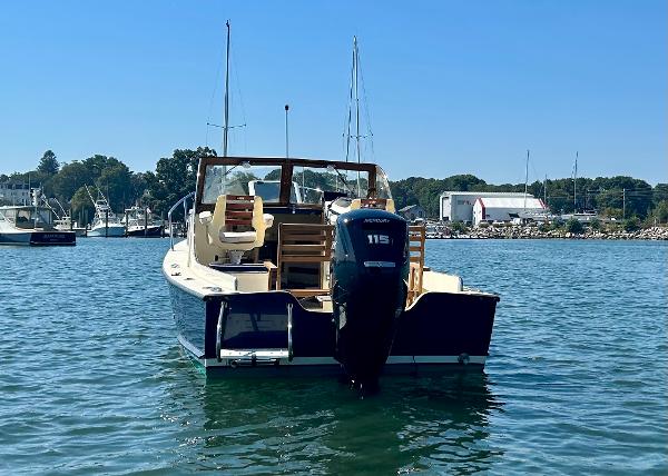 Slide: The Image of 2021 Seaway 21 Seafarer Cuddy boat on water, rear view with outboard motor. - 2