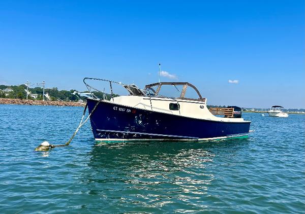 Slide: The Image of 2021 Seaway 21 Seafarer Cuddy boat anchored on calm water under clear blue sky. - 4