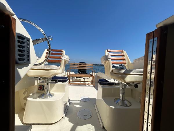 Slide: The Image of 2021 Seaway 21 Seafarer Cuddy boat interior with steering wheel and seating, under clear blue sky. - 5