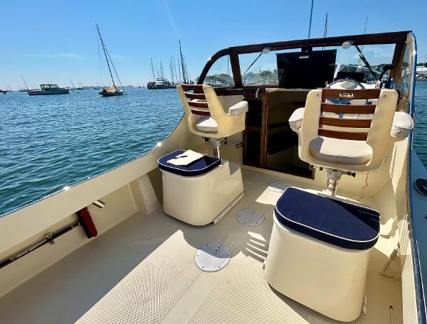 Slide: The Image of 2021 Seaway 21 Seafarer Cuddy boat interior with seating, on a sunny day by the water. - 6