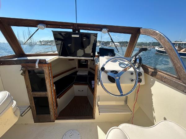 Slide: The Image of 2021 Seaway 21 Seafarer Cuddy boat interior with steering wheel and cabin view. - 9