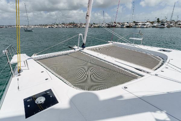 Slide: The Image of 2024 Seawind 1600 catamaran deck with netting, docked in a marina. - 10