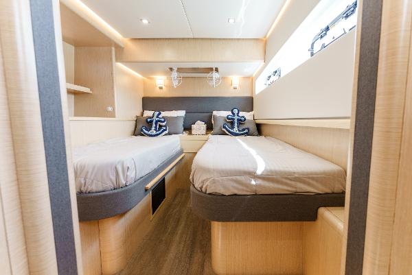 Slide: The Image of Luxurious 2024 Seawind 1600 cabin with twin beds and nautical decor. - 40